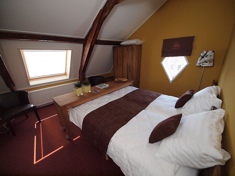 Authentieke elementen van de voormalige hooizolder hebben de Bosgra’s ook in de hotelkamers intact gelaten.