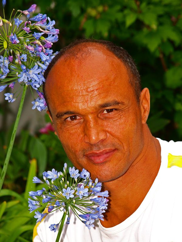 Daniël Hoek bij een Afrikaanse bloem in de tuin van Michiel en Hanneke Hoek in Oudemirdum.