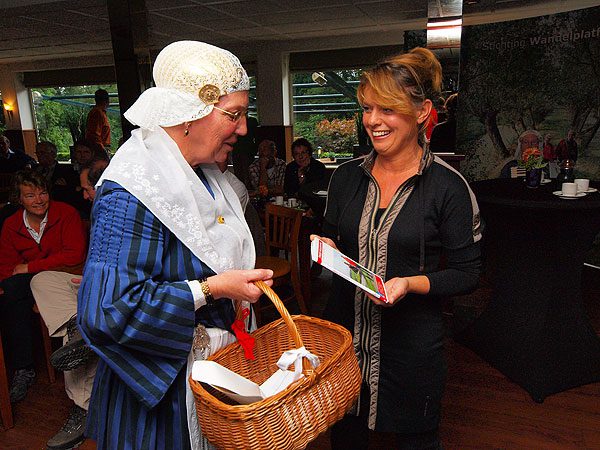 Een lid van de folkloristische dansgroep Dokkumer Skotsploech overhandigde toerismegedeputeerde mr.drs. Jannewietske de Vries de eerste wandelgids ‘Friese Woudenpad’ in restaurant Het Witte Huis in Olterterp.