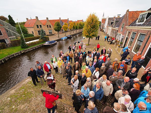 Zo verkouden als de uitlaat van een rondvaartboot, maar Sloten’s stadsomroeper Pieter Haringsma gaat door. Waar andere gidsen piepen en kraken en om stervensbegeleiding verzoeken als een groep groter is dan 50 man, heeft het stemkanon van Sloten geen moeite met het overbrengen van Friese humor en historie aan 130 gasten.