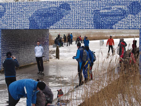 Schaatsen bij de Elfsteden tegeltjesbrug bij Gytsjerk (Giekerk) is even verleden tijd. En anders maar op de fiets naar één van de beroemdste Elfsteden-bruggen. Elfsteden fietsarrangementen vindt u op www.frieslandhollandtravel.nl Foto: Friesland Holland Nieuwsdienst, Marian de Wolff.