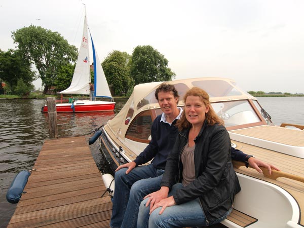 Willem Stroo en zijn echtgenote bij de nieuwe bakdekkruiser. Op de achtergrond een Fox-kajuitzeiljachtje. Fox’en, polyvalken en sloepen maken ook deel uit van hun verhuurvloot.