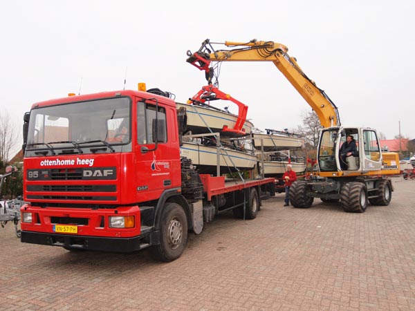 Chauffeur André had de lading al vastgesjord, gezien de hijsbanden, maar op de foto doet Johan Potma voor de fotograaf even alsof hij een polyvalk op de motorwagen zet. Baas Kees Alberts kijkt toe. De zeilboten op de truck met aanhanger zijn naar de Zeeuwse zeilschool De Viking in Wolphaartsdijk gegaan.