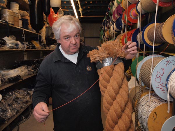Als u er geen touw meer aan vast kunt knopen, stap dan maar naar Henk de Boer. Hij zit zijn hele leven al in de watersportartikelen en jachtbouw. Op de foto toont hij het dunste touw uit de collectie, 1 mm, en het dikste, 200 mm.