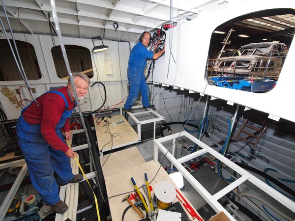 Albert van Houten (voorgrond) en Erik Mennega (achter) moeten het hoofd er goed bij hebben bij de installatie van de techniek die doet denken aan die van een royal class touringcar of truckcamper.