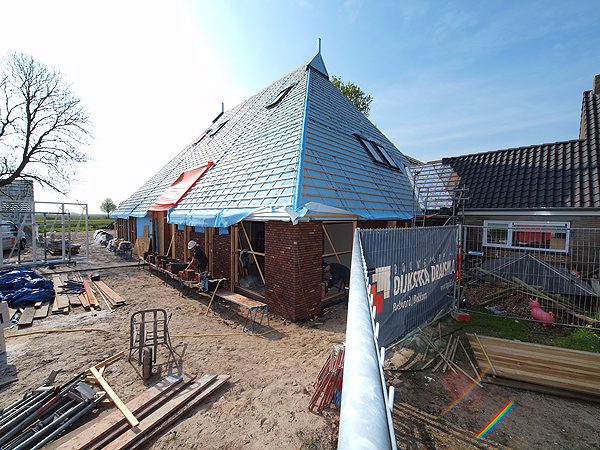 Medewerkers van Bouwgroep Dijkstra Draisma bouwen wat Penta Architecten uit Harlingen ontworpen heeft: een Pitch en Putt clubhuis in boerderijstijl.