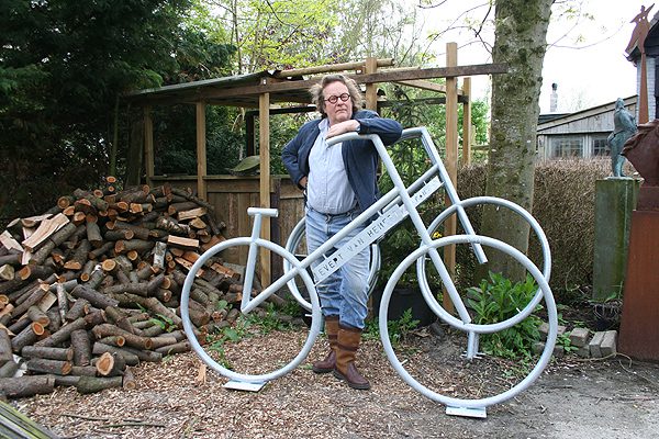 Evert van Hemert, directeur van de ‘Eerste Oprechter Kolderwolder Fietsenfabriek’, bij zijn stalen ros. Representatief werk van de Hollandse Fries vind je onder andere op de Gaasterlandse beeldenroute langs het meer de Fluezen (Fluessen): de Famkes van Kolderwolde.