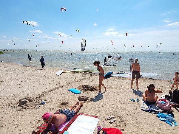 Schermen van kitesurfers vullen de weiden en de hemel bij Mirns.