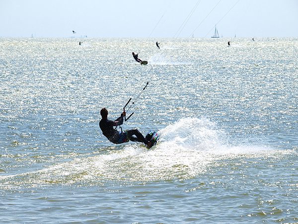 Schermen van kitesurfers vullen de weiden en de hemel bij Mirns.