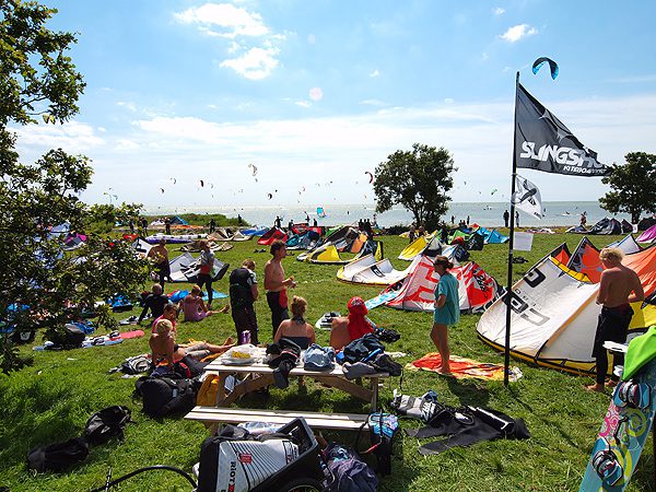 Schermen van kitesurfers vullen de weiden en de hemel bij Mirns.