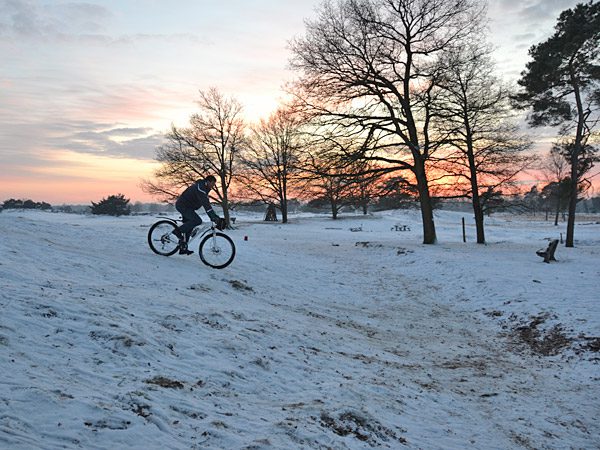 Het mountainbiken in het Drents-Friese Wold gaat door tot zonsondergang.