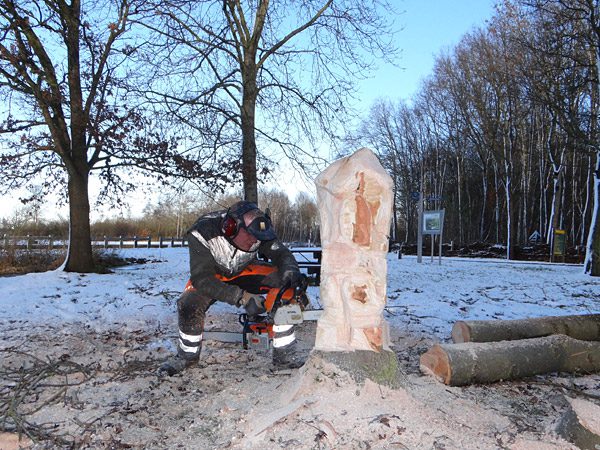 Harm Eigenraam zaagt een kabouterfiguur.